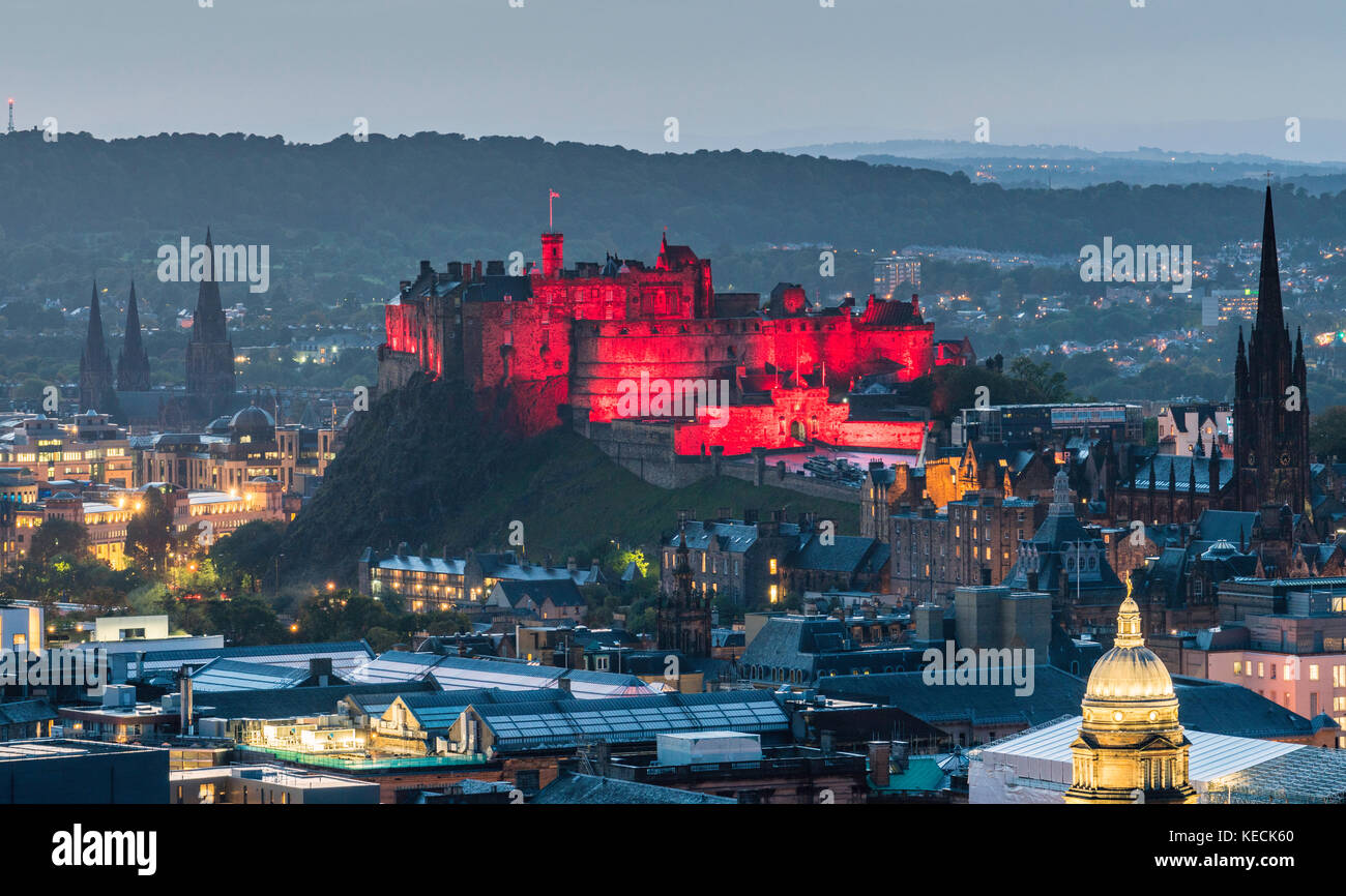 Vista del Castello di Edimburgo illuminata in rosso la sera da Salisbury Crags a Edimburgo, Scozia, Regno Unito. Foto Stock
