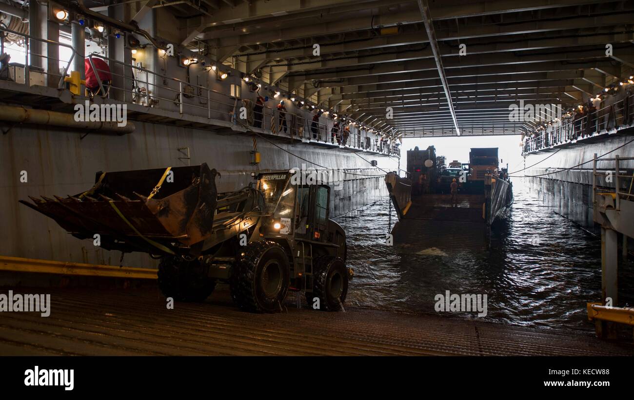 Sailor alleggerimento del carico di un trattore da Landing Craft unità (LCU) 1656 Foto Stock