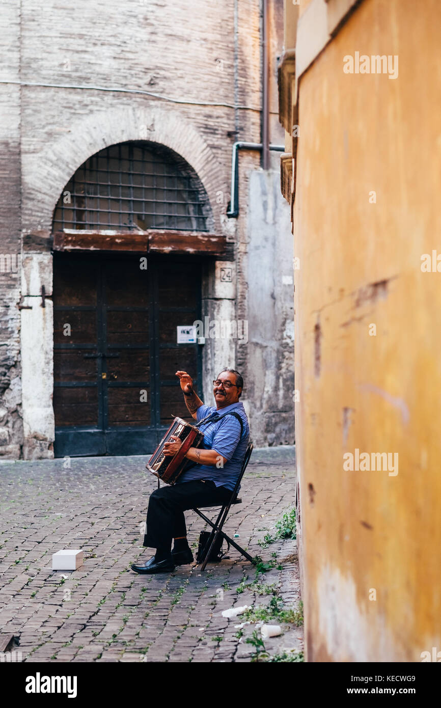 Un uomo suona la fisarmonica nel quartiere Ghetto di Roma, Italia Foto Stock