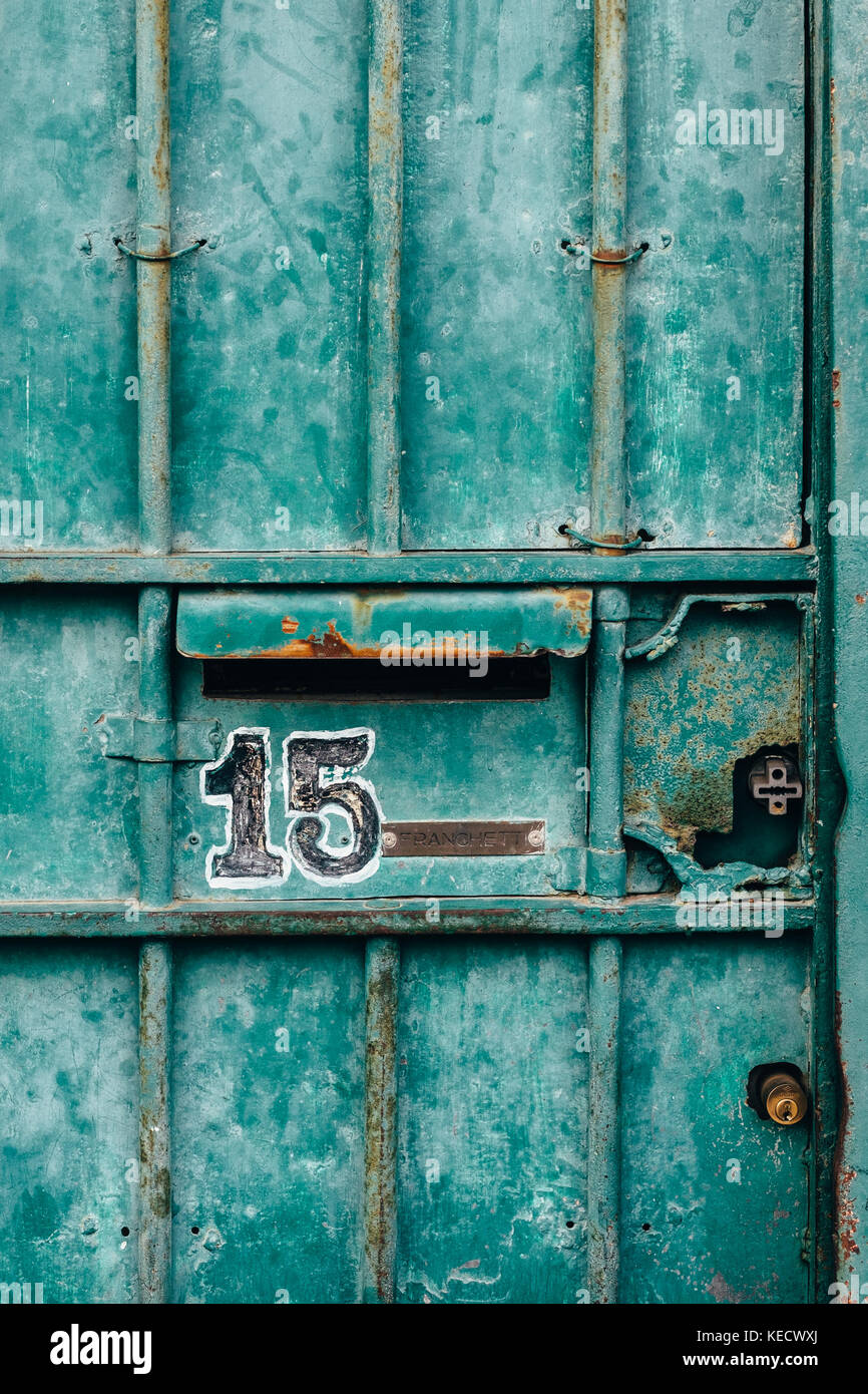 Un verde usurato porta di metallo in italia a Roma il quartiere di trastevere. un numero è impresse sulla porta. Foto Stock