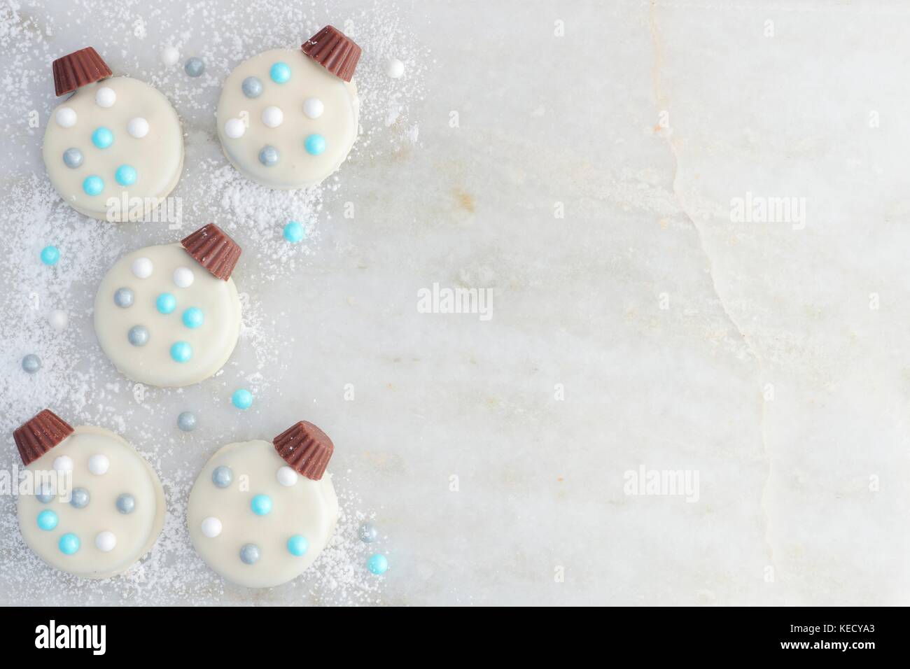 Il Natale di cioccolato bianco Biscotti di ornamento, bordo laterale su un marmo bianco sullo sfondo Foto Stock