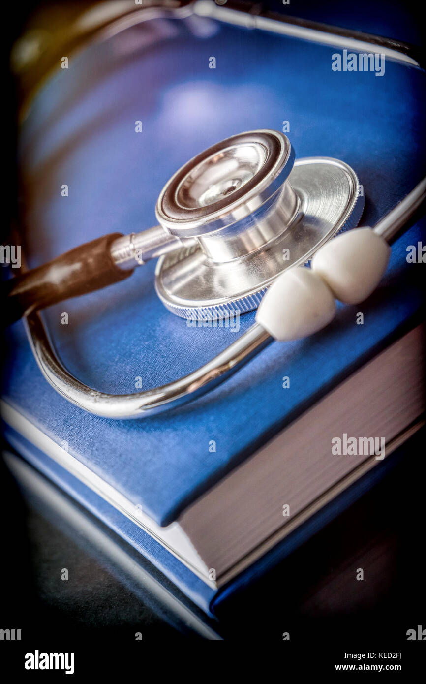 Uno stetoscopio in un libro di medicina, immagine concettuale Foto Stock