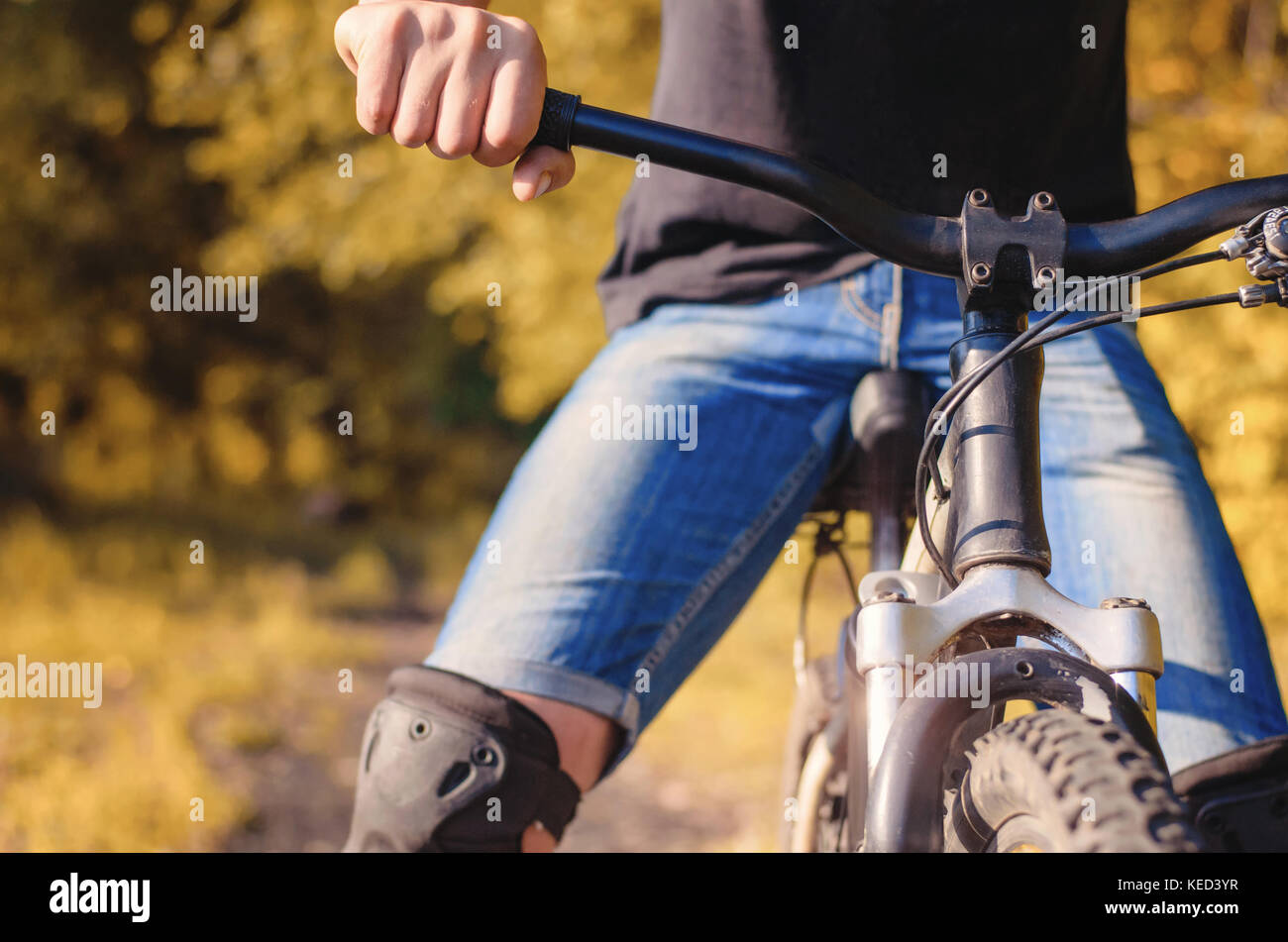 Close-up di un giovane di mano sul volante di una montagna off-road in bicicletta in tempo soleggiato all'esterno. equitazione sulla cross-country canzoni. Foto Stock