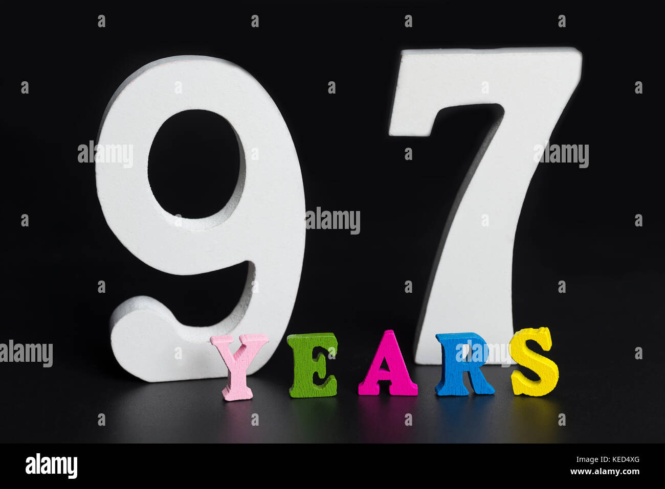 Lettere e numeri novanta sette anni su un isolato nero lo sfondo. Foto Stock