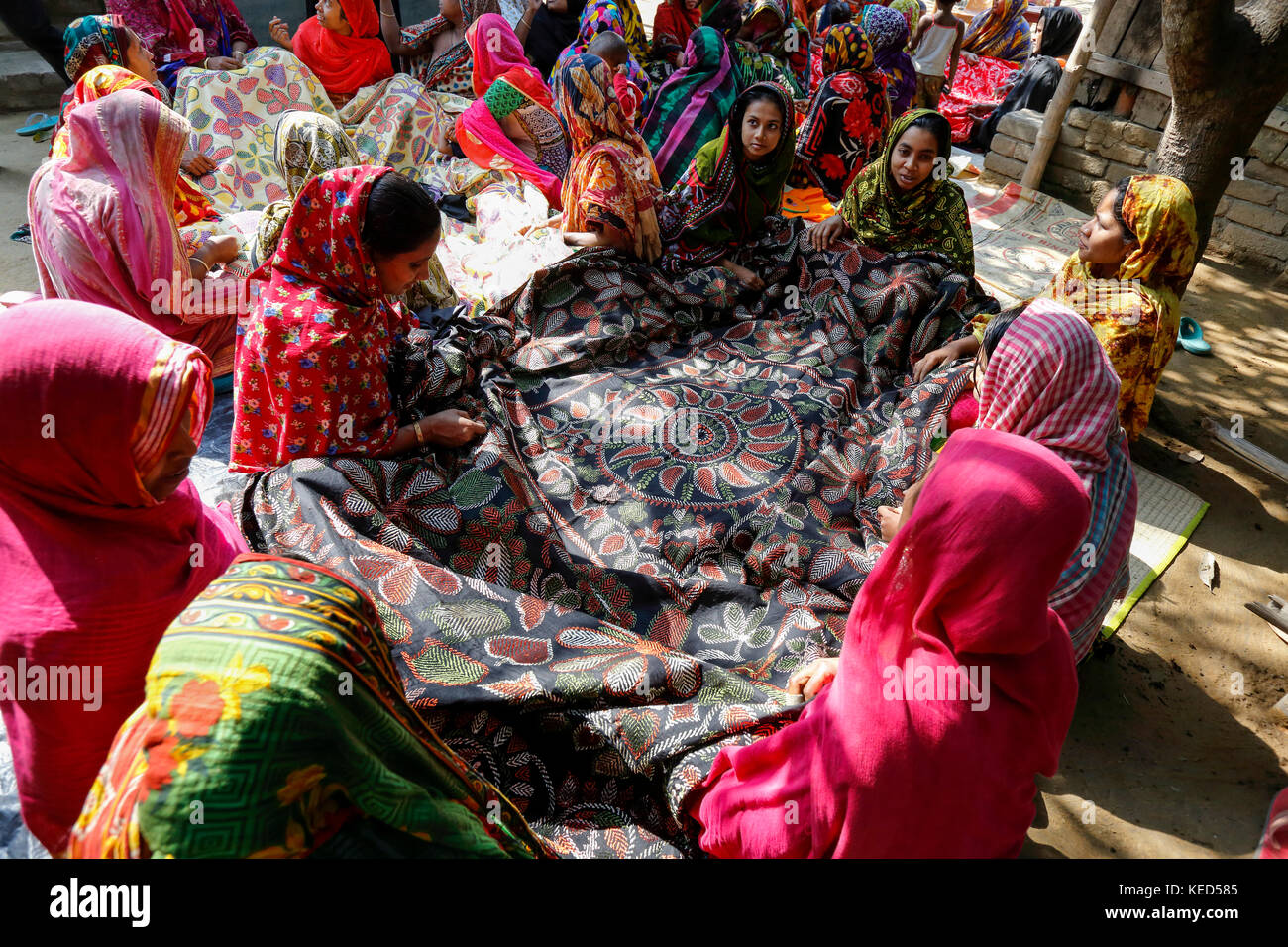 Le donne rurali rendono nakshi kantha, un tipo di quilt ricamato in un villaggio di jessore in Bangladesh. Foto Stock