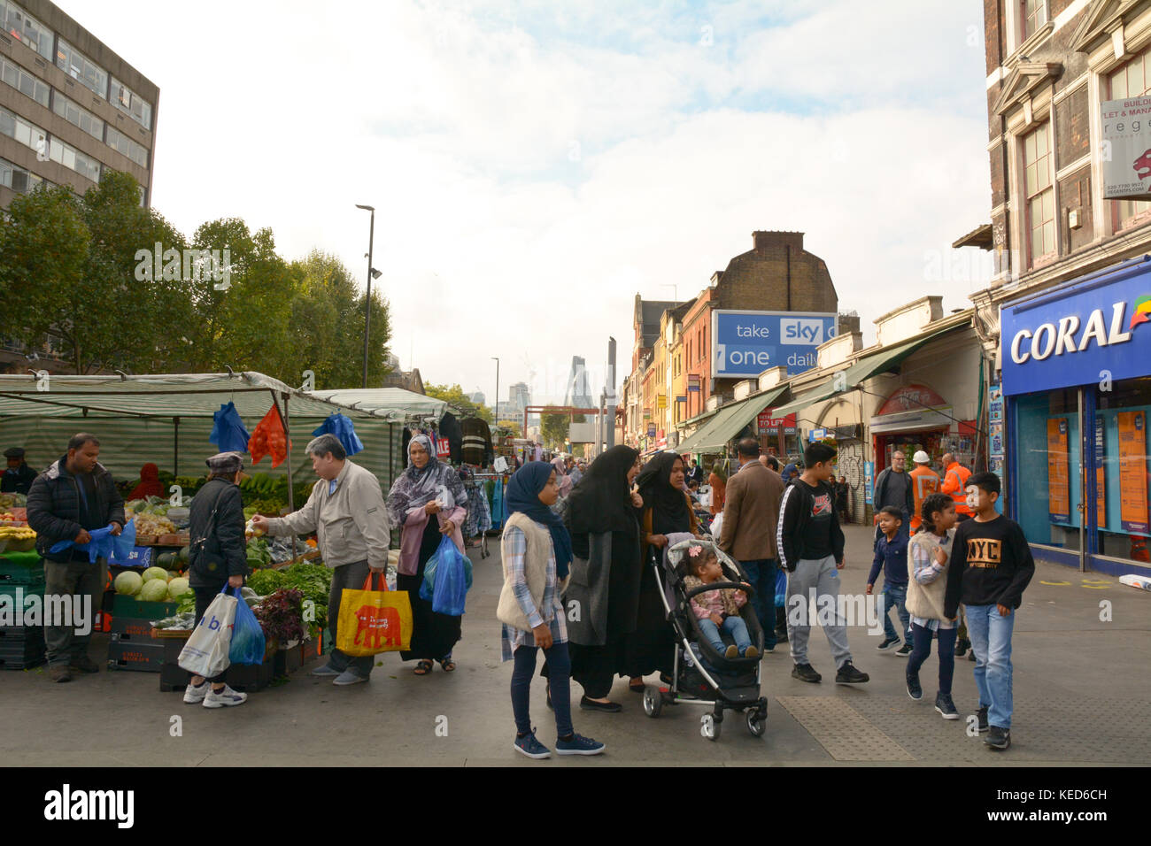 People shopping presso le bancarelle del mercato su Mile End Road a Whitechapel London Inghilterra England Foto Stock