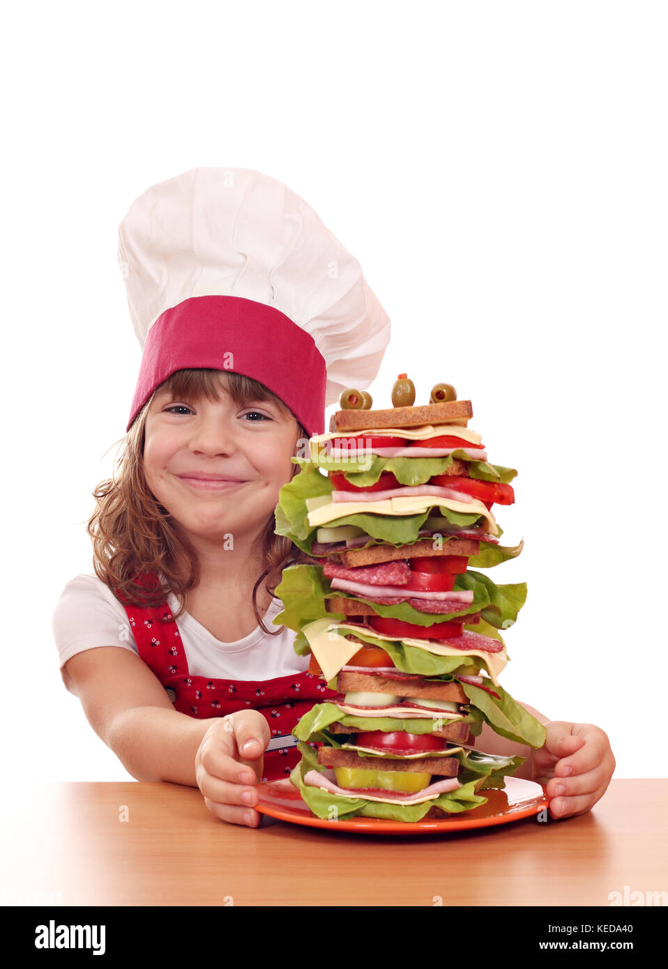 Felice bambina cook con grande panino Foto Stock