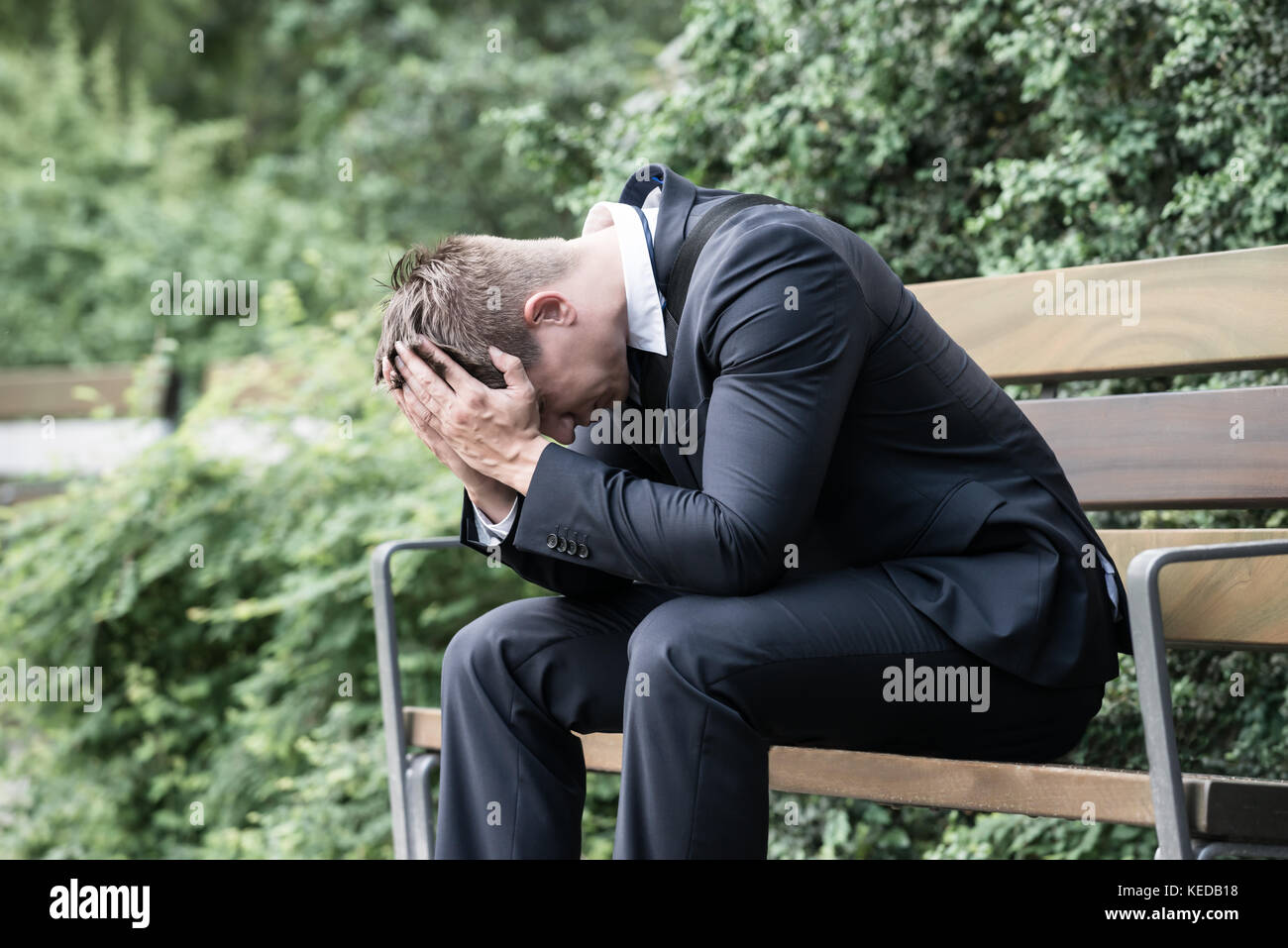 Foto sconvolto giovane impreditore seduta sul banco di lavoro Foto Stock