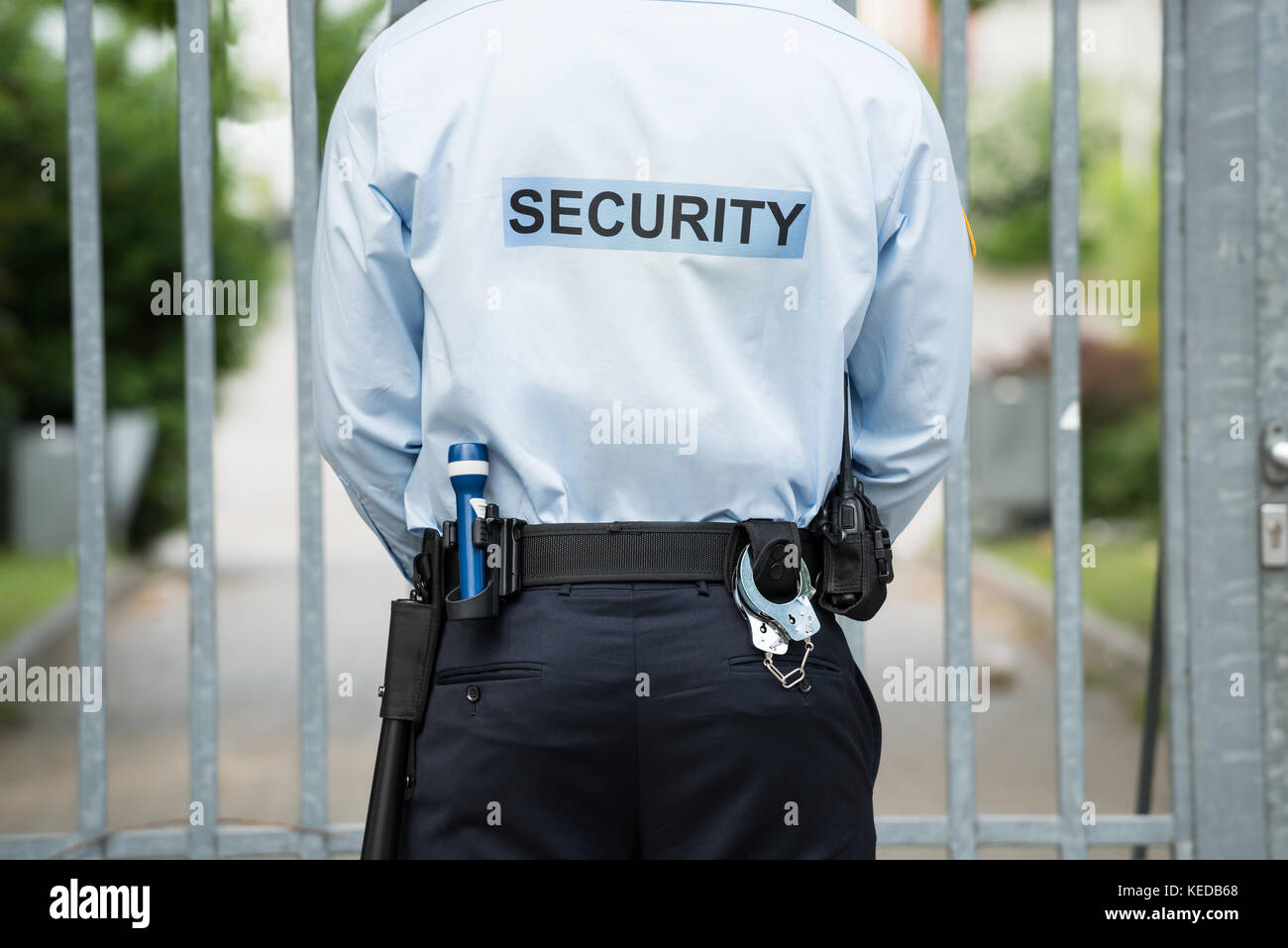 Vista posteriore di una guardia di sicurezza in piedi nella parte anteriore della porta Foto Stock
