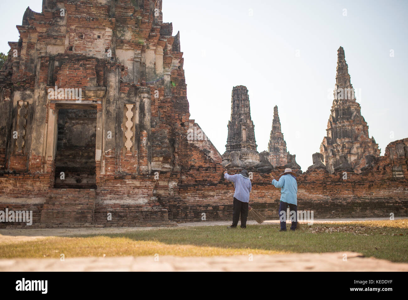 Due lavoratori sono raccogliere le foglie in Wat Chaiwatthanaram complesso nella città di Ayutthaya, Thailandia. Foto Stock