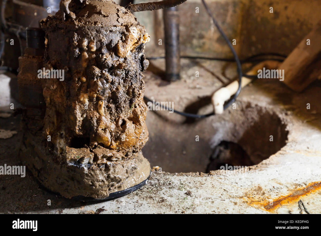Una vecchia pompa coppa coperta in depositi di minerali e fango davanti una coppa aperta pit. In Ontario, Canada. Foto Stock
