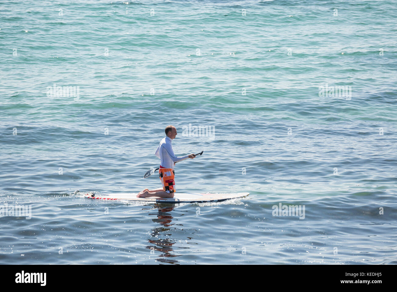 Stand Up Paddle boarder pagaia in ginocchio Foto Stock