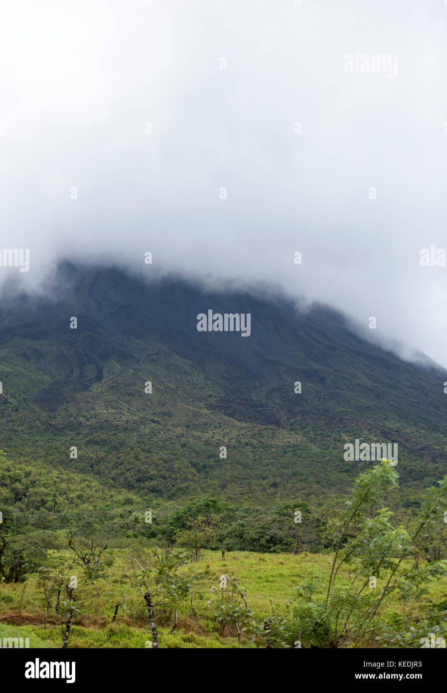 Basse nubi che copre la punta del vulcano Arenal, La Fortuna, Costa Rica Foto Stock