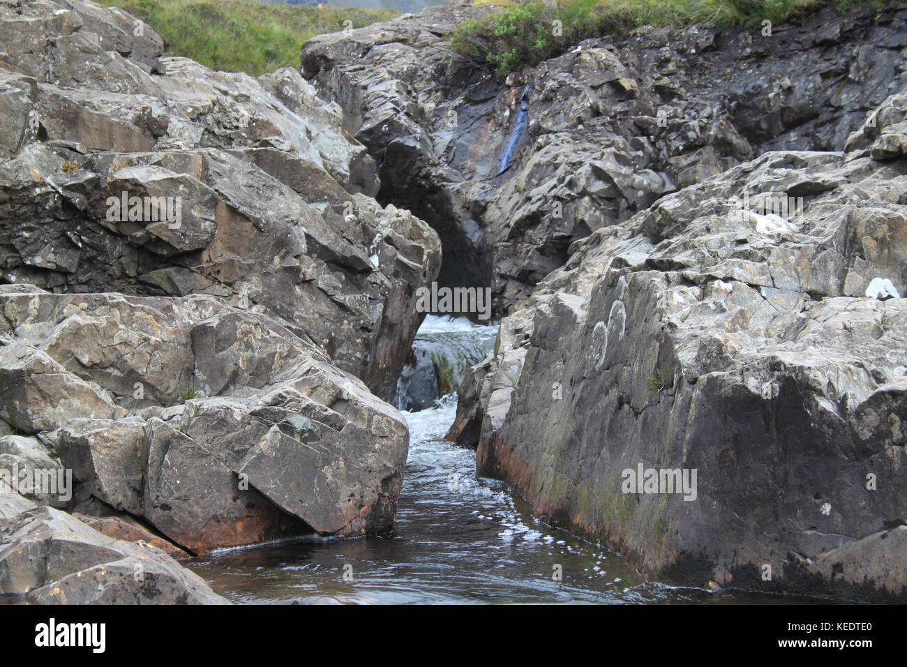Un flusso che passa attraverso due pareti di roccia Foto Stock