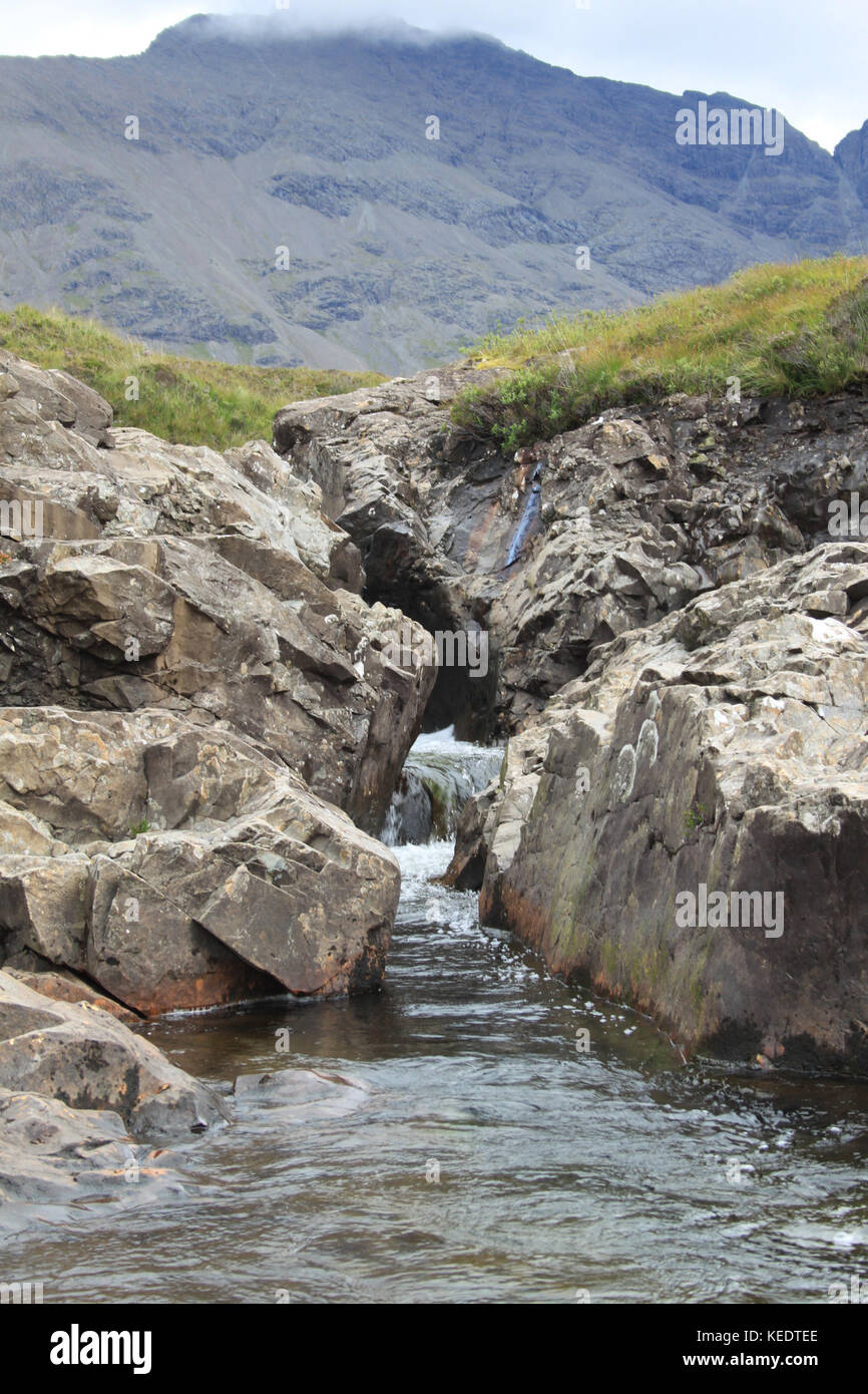 Un flusso che passa attraverso due pareti di roccia Foto Stock