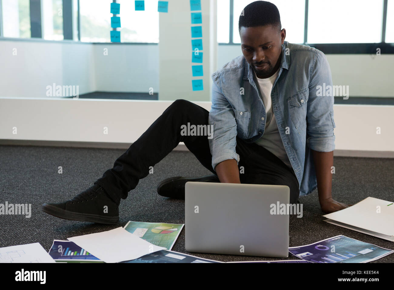 Executive maschio utilizzando computer portatile in ufficio futuristico Foto Stock