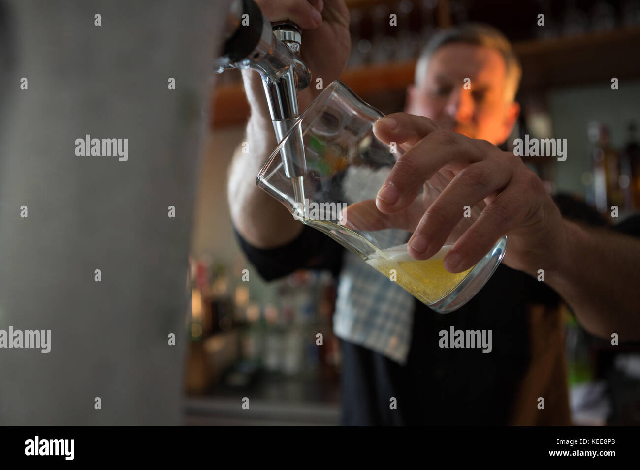 Il birraio imbottigliamento della birra nel bicchiere da birra birra dalla pompa in bar Foto Stock