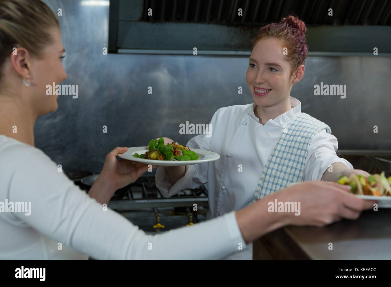 Chef femmina il contenimento di cibo piastre in cucina Foto Stock