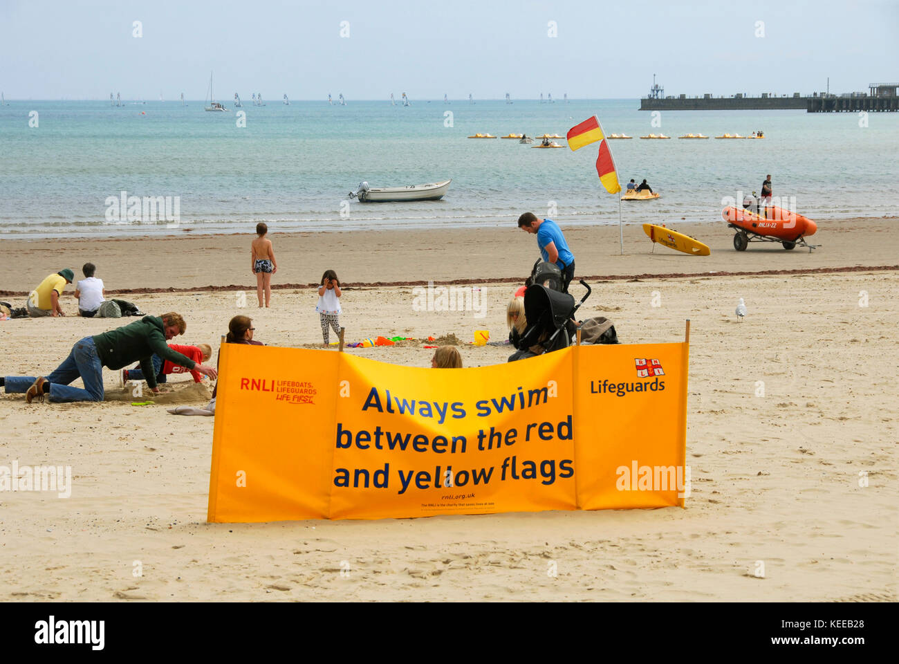Avviso sulla spiaggia per nuotare tra bandiere rosse e gialle Foto Stock