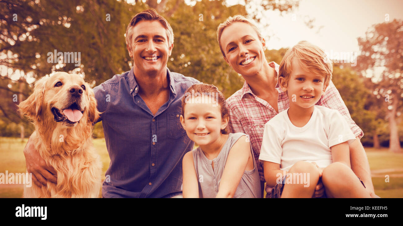 Famiglia godendo con il cane al parco sulla giornata di sole Foto Stock