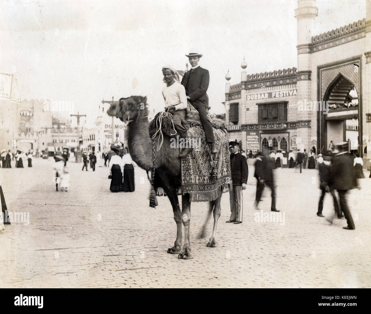 Una corsa in cammello attraverso il luccio. (Bianco Uomo a dorso di un cammello con un Egiziano driver nella sezione di luccio del 1904 Fiera Mondiale) Foto Stock