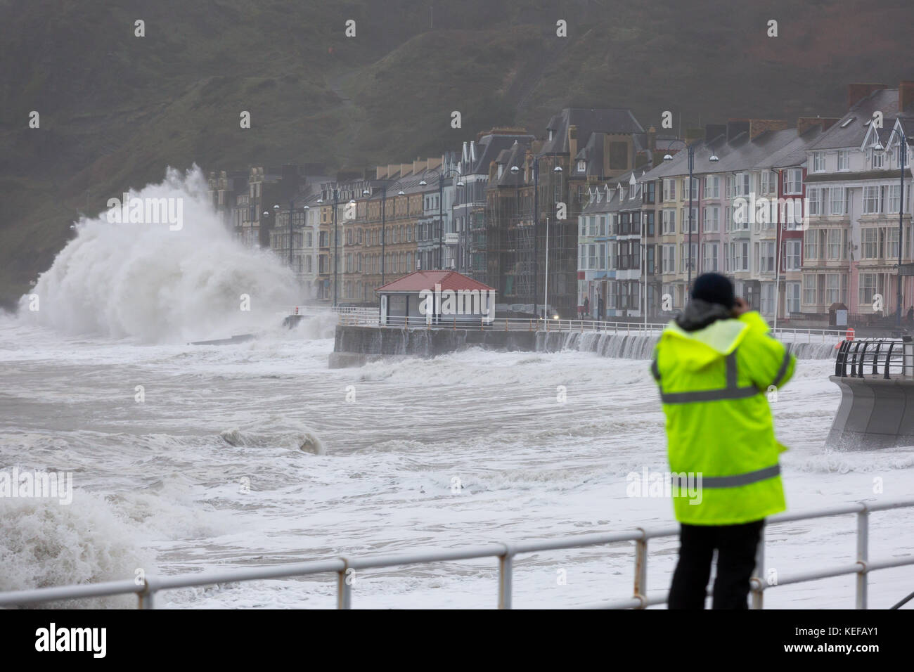 Fotografo: Keith Morris fotografando Brian Storm come alta marea porta grandi onde che urtano contro Aberystwyth promenade e difese del mare. Credito: Ian Jones/Alamy Live News Foto Stock