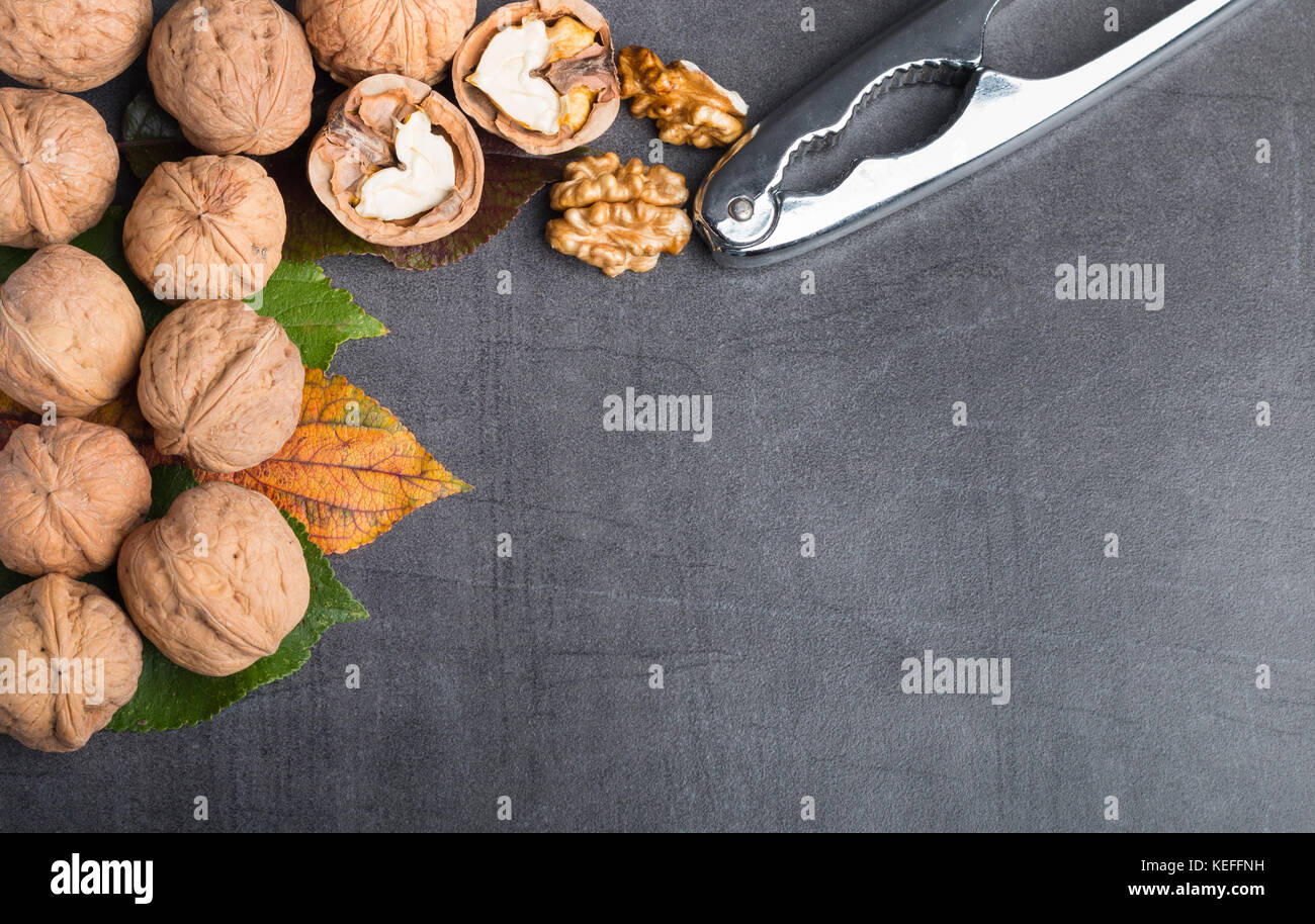 Bio le noci su un tavolo in pietra con uno schiaccianoci Foto Stock