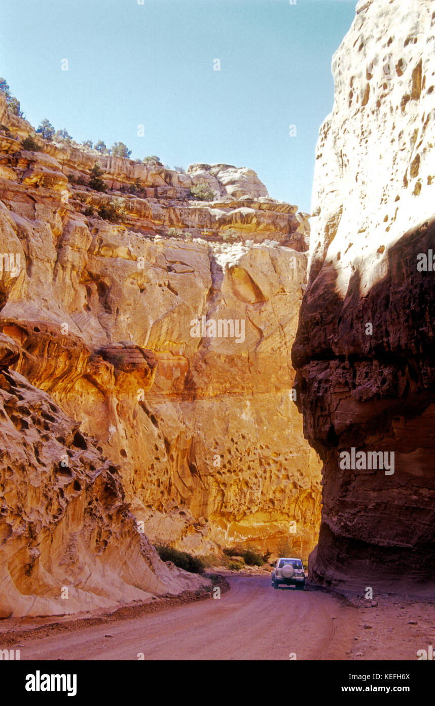 Alte pareti di incandescente arenaria Wingate dwarf autovetture sul Parco nazionale di Capitol Reef's Scenic Drive nel centro-sud della Utah. Foto Stock