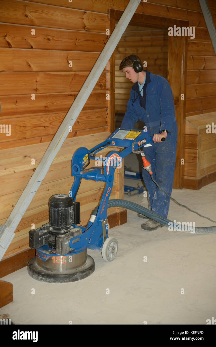Greymouth, Nuova Zelanda, Giugno 8, 2017: un commerciante lucidi un pavimento in cemento con una smerigliatrice di grandi dimensioni. Foto Stock