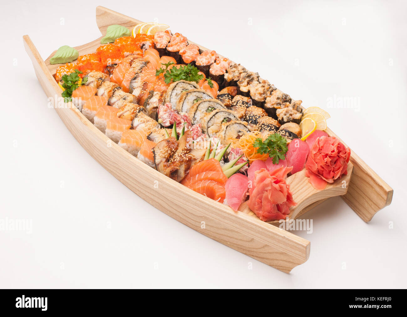 Assortimento di sushi in barca in legno piastra su sfondo bianco Foto Stock