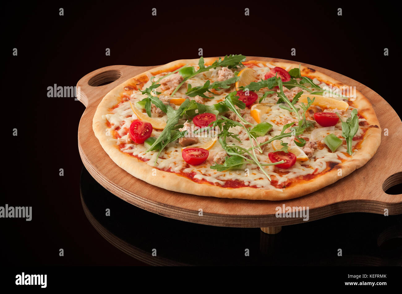 Una pizza su un vassoio in legno Foto Stock