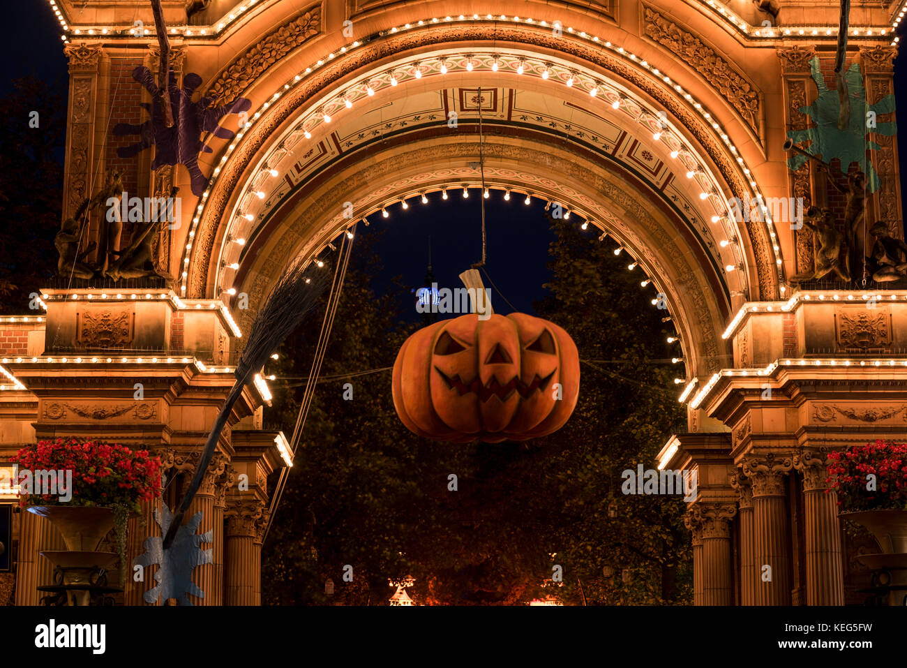 Zucca di Halloween di fronte alla illuminata ingresso principale dei Giardini di Tivoli, Copenhague, Dinamarca Foto Stock