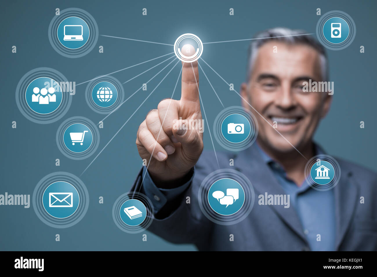 Imprenditore sorridente utilizzando una interfaccia virtuale con le icone delle app, egli sta accedendo a un cruscotto virtuale e networking su uno schermo visivo Foto Stock