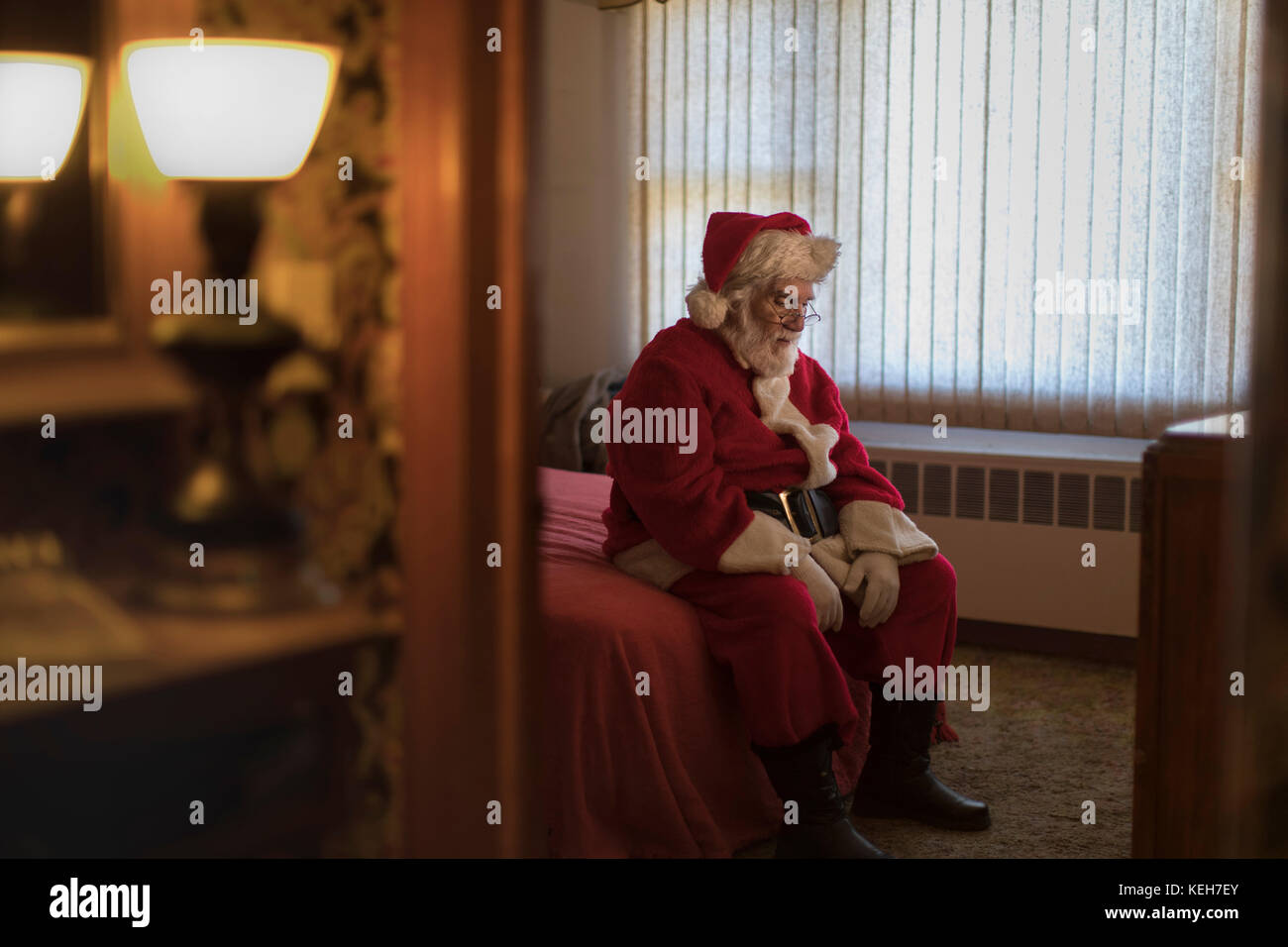 Premuto Caucasian Santa seduta sul letto Foto Stock