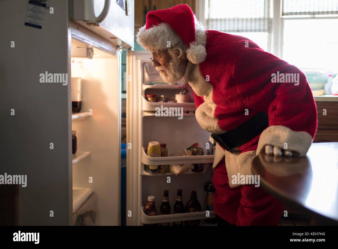 Caucasian Santa cercando in frigorifero Foto Stock