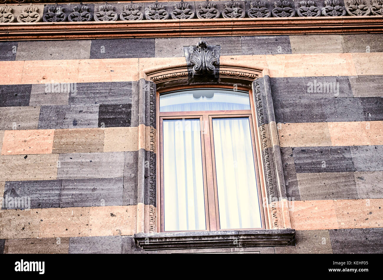 Pietra scolpita pattern sul cornicione e finestra ad arco telaio con il foglio stilizzato ornamento nel centrato Foto Stock