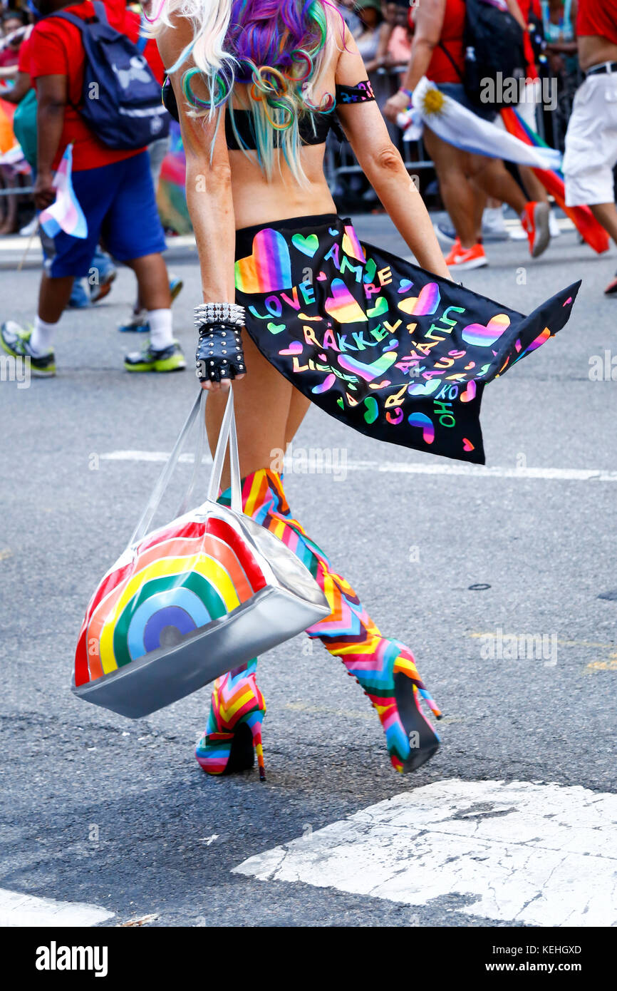 Persona che indossa stivali con tacco alto che portano borsetta in fiera parata Foto Stock