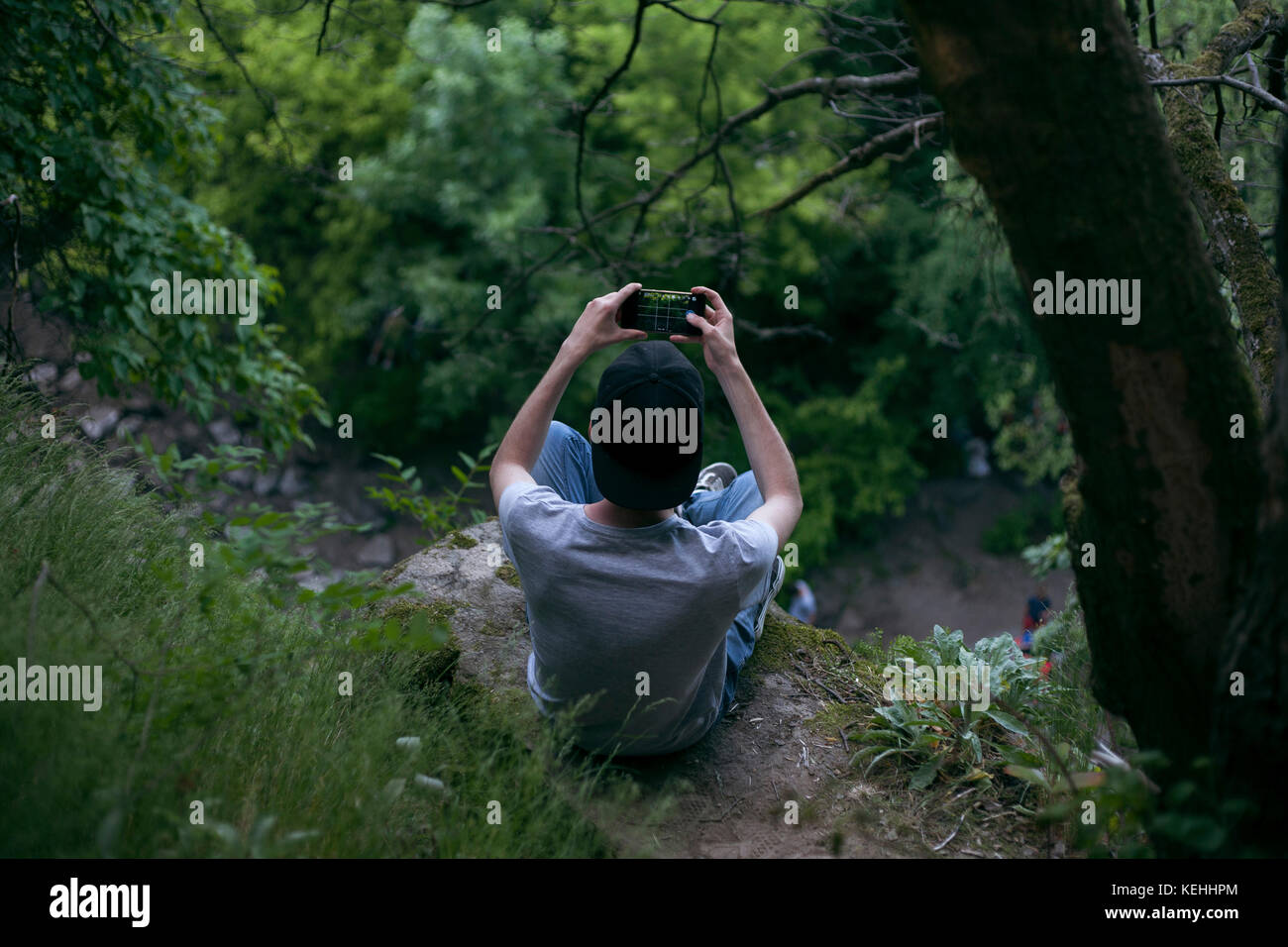Uomo caucasico fotografando con il telefono cellulare in legno Foto Stock