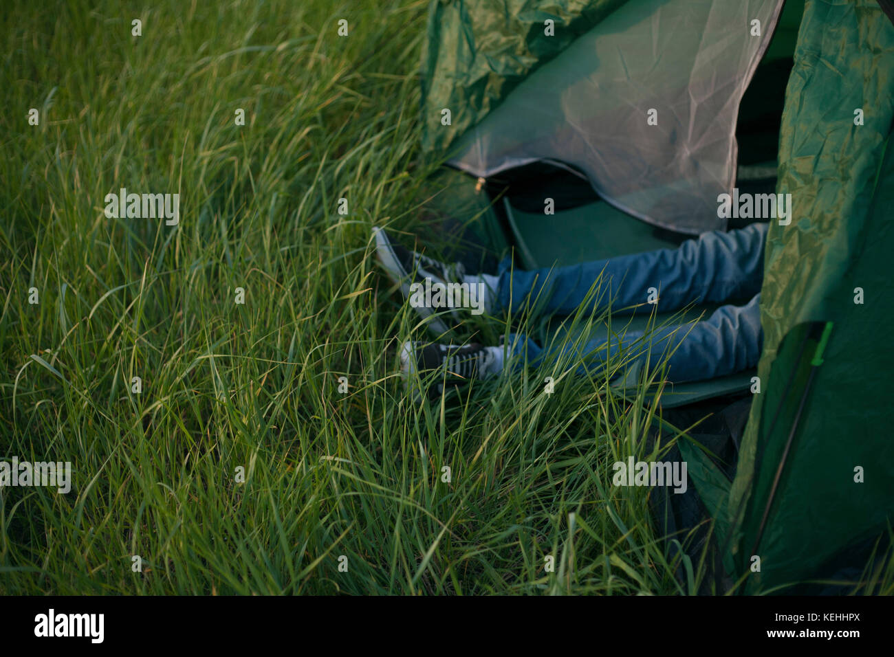 Gambe di uomo caucasico che si stese in tenda Foto Stock
