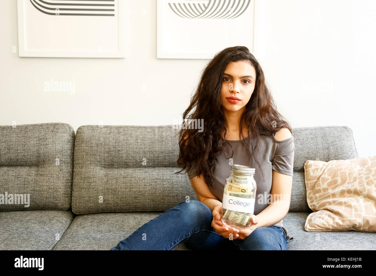 Ritratto di donna di razza mista che tiene vaso di soldi per l'università Foto Stock