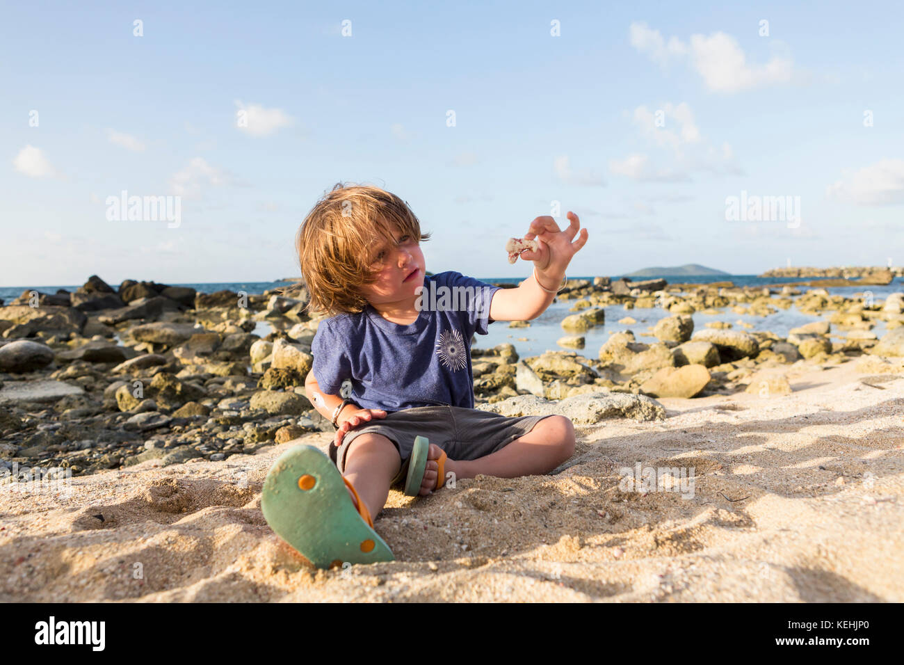 Caucasico ragazzo che gioca nella sabbia in spiaggia Foto Stock
