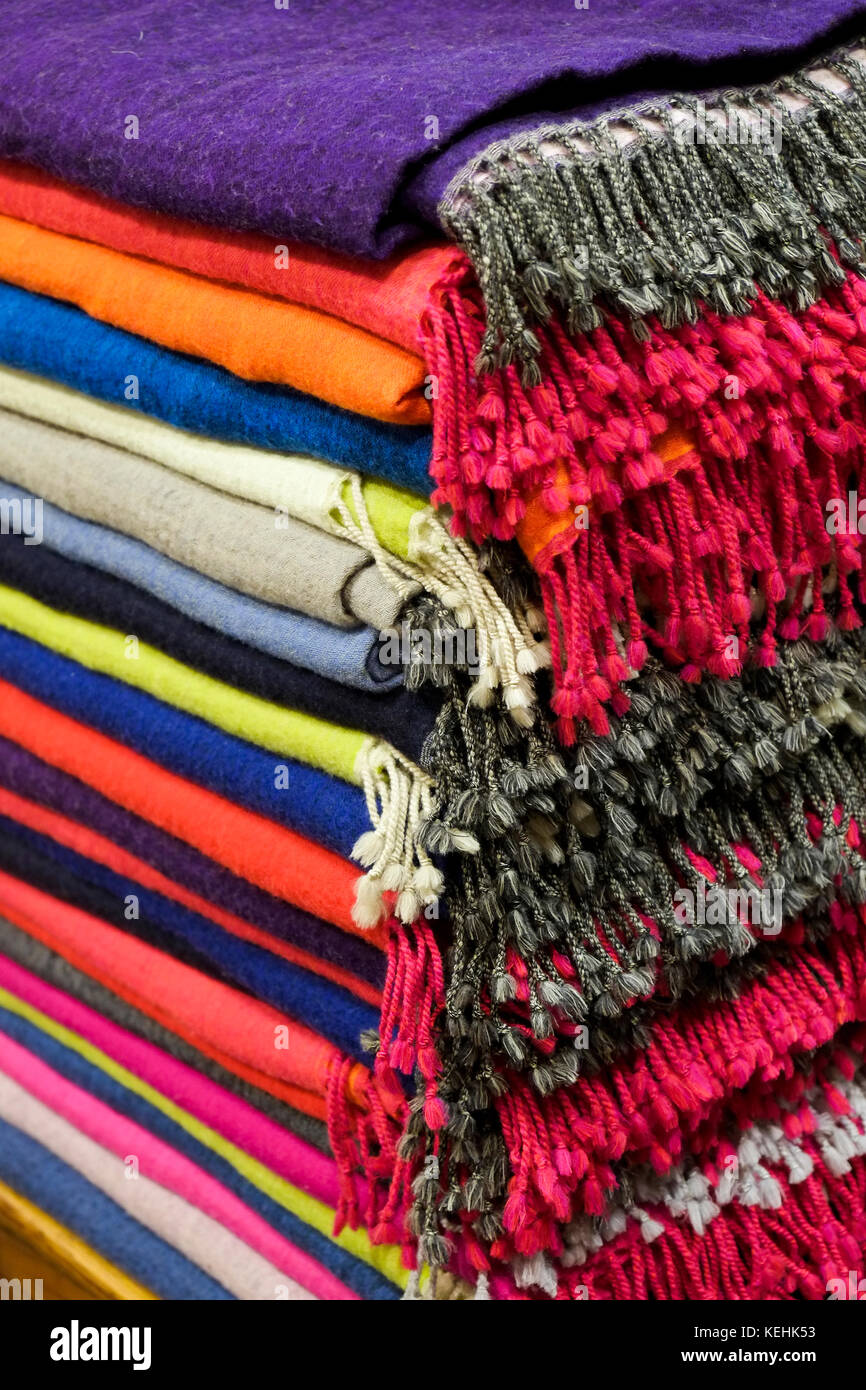 Pile di coperte multicolore con frange Foto Stock