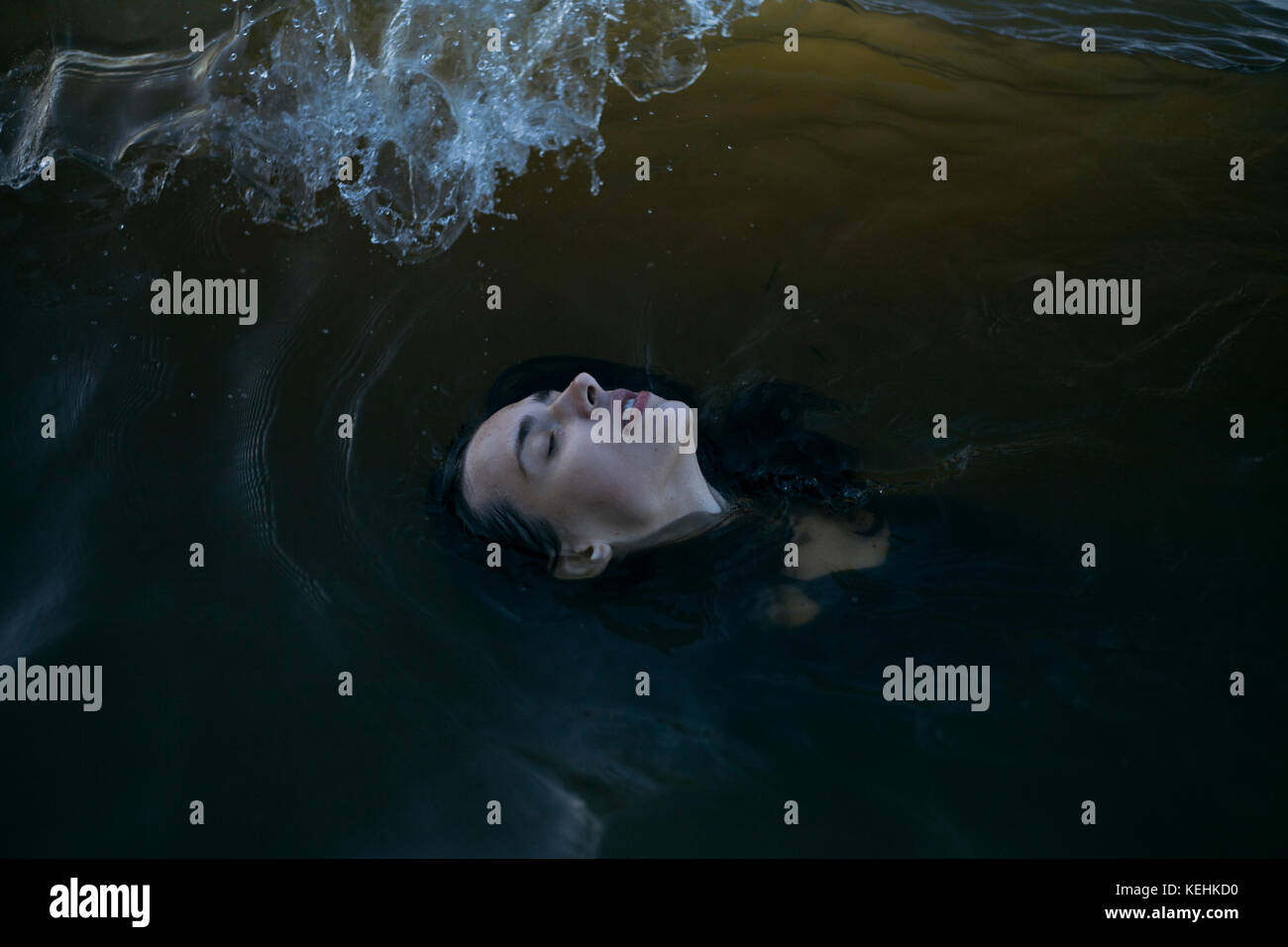 Donna caucasica che galleggia in oceano con gli occhi chiusi Foto Stock
