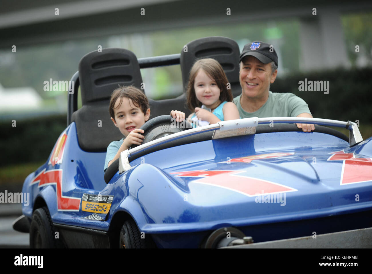 (FEB. 4, 2011): Emmy Award-winnng TV host e Grammy premiato comico Jon Stewart prende un giro 4 febbraio 2011 sulla Tomorrowland Indy Speedway al Magic Kingdom parco a tema di Lake Buena Vista, Fl. con i suoi bambini Nate (a sinistra, 6 anni) e Maggie (centro, 5 anni). La visita del 4 febbraio ha avuto luogo il 5th compleanno di Maggie, mentre Stewart e la sua famiglia hanno festeggiato con gli amici al Walt Disney World Theme Park. Credito: Hoo-me.com/MediaPunch Foto Stock