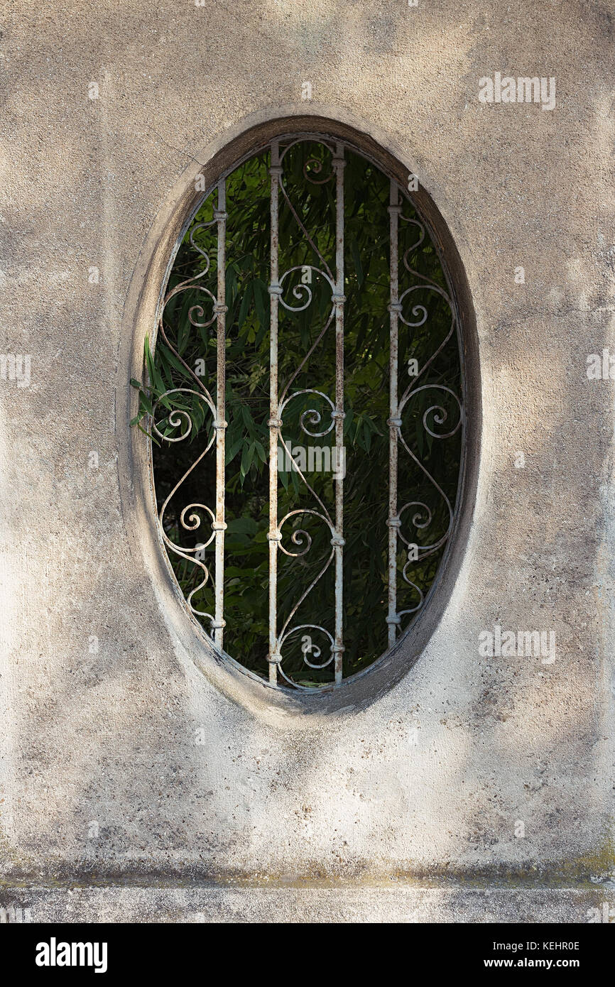 Recinzione in pietra con apertura circolare e in ferro battuto Foto Stock