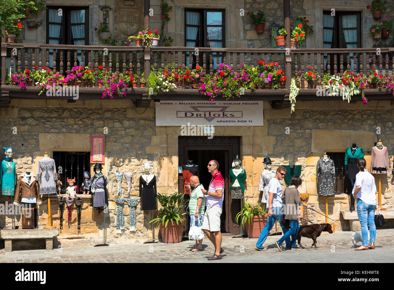 I turisti e la gente del luogo in Calle de los Arzobispos nel centro storico di Comillas, Cantabria, Spagna settentrionale Foto Stock