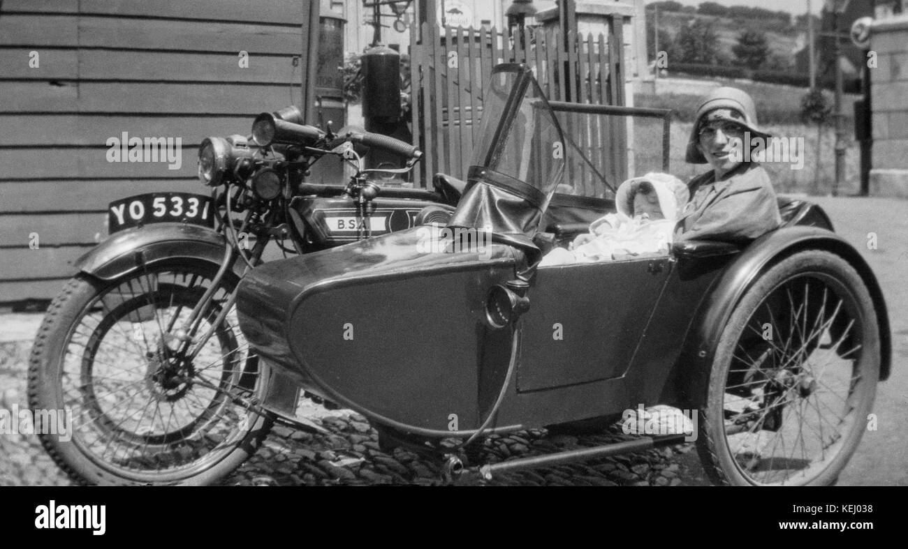 Un vintage 1920s BSA moto e sidecar, registrazione YO 5331, con una donna e il suo bambino in seduta il sidecar. Immagine mostra la moda del periodo. Foto Stock