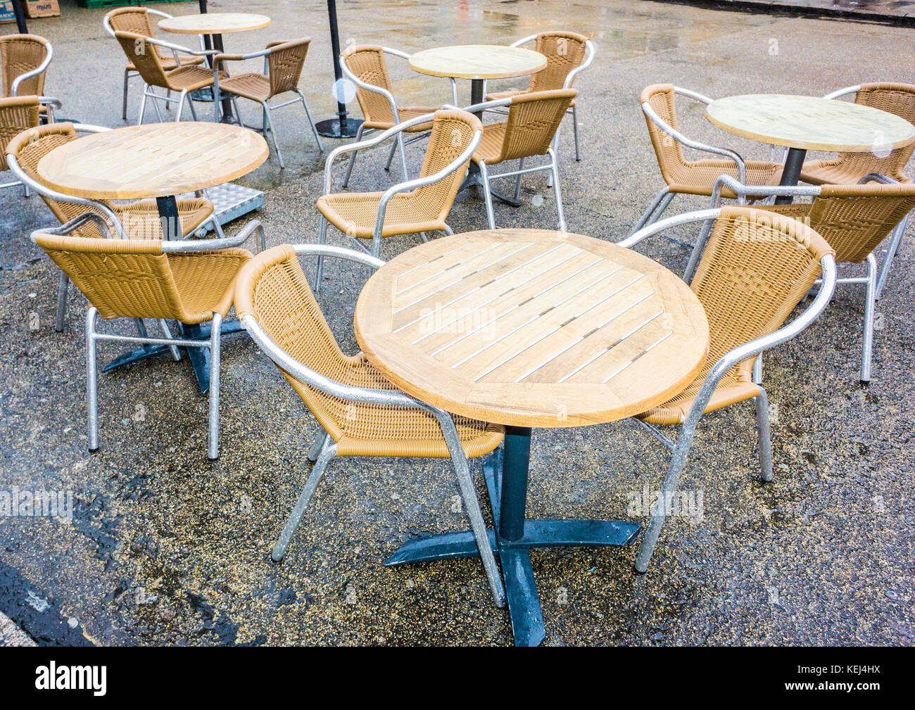 Svuotare i tavoli e le sedie al di fuori di un coffee shop in un giorno di pioggia. Foto Stock