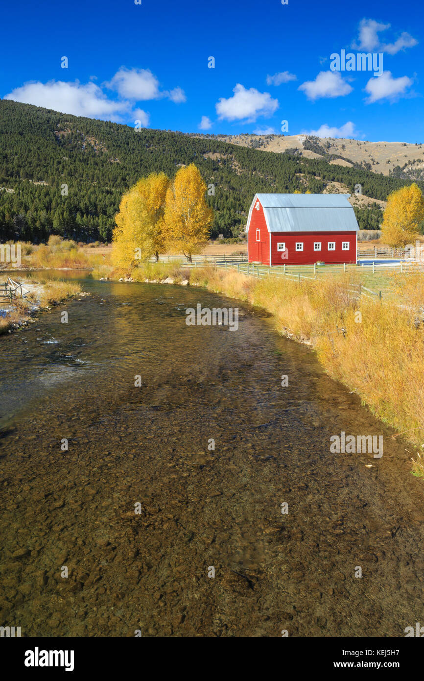Granaio rosso e i colori dell'autunno lungo il fiume rubino vicino ontano, montana Foto Stock