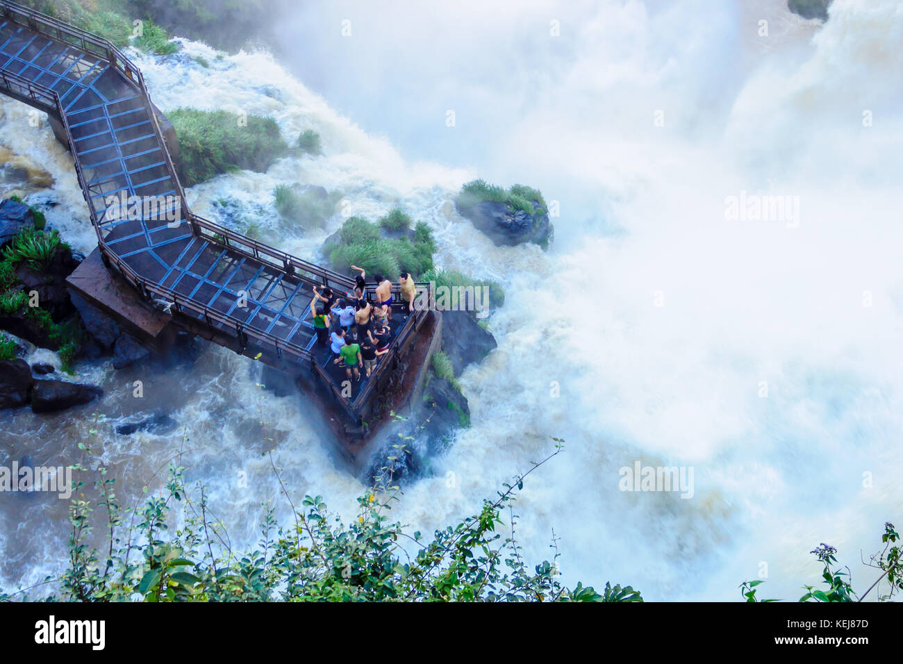 PUERTO IGUAZU, ARGENTINA - 19 SETTEMBRE 2009: I turisti si raffreddano nello spruzzo delle possenti cascate di Iguazu, nel Parco Nazionale di Iguazu al confine di Foto Stock